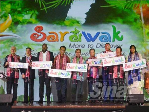 Abang Johari (lima dari kanan) diiringi Mohamaddin (empat dari kanan) dan Abdul Karim (empat dari kiri) memegang sepanduk Sarawak sebagai simbolik mempromosikan pelancongan Sarawak pada Majlis Makan Malam Sarawak Tourism di Kuala Lumpur semalam. - Foto SHARIFUDIN ABDUL RAHIM