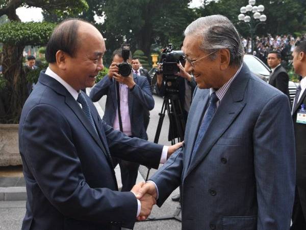 Perdana Menteri Tun Dr Mahathir Mohamad bersalaman bersama rakan sejawatnya Nguyen Xuan Phuc pada sambutan rasmi di Istana Presiden, Hanoi, hari ini. - Foto Bernama