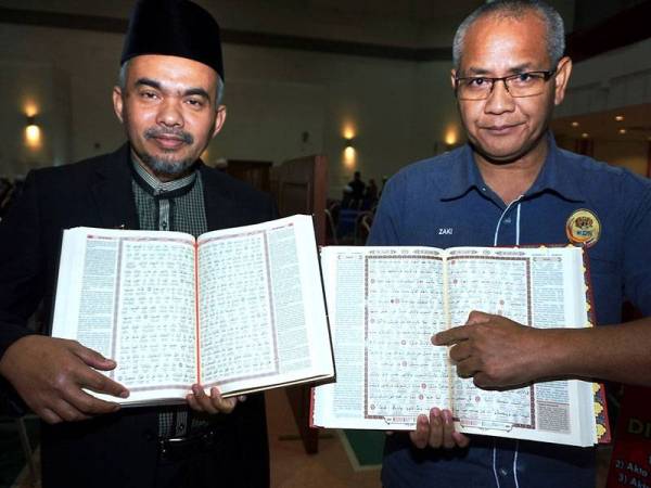 Ketua Penolong Setiausaha Kanan Seksyen Regulatori Hadith Kementerian Dalam Negeri (KDN) Kamaldin Mohd Damin (kiri) dan Pengarah Penguatkuasaan dan Kawalan (PKK) KDN Kedah menunjukkan cetakan Al-Quran bersama tulisan rumi yang berjaya dirampas dan dipamerkan pada Majlis Penutup Seminar Pemuliaan Al-Quran dan Rasm Uthmani di Dewan KDN, Anak Bukit hari ini. - Foto BERNAMA