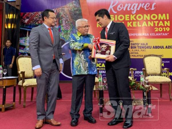 Mohd Radzi (kanan) menerima cenderahati daripada Hussamuddin selepas menyampaikan ucaptama pada Kongres Sosioekonomi Kelantan ‘Inklusiviti Dalam Membangunkan Sosioekonomi Negeri Kelantan’ di UMK hari ini.