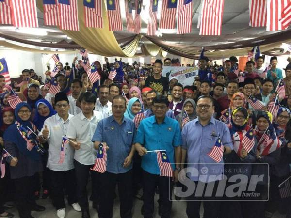 Mohd Izhar bersama warga KKJ mengibarkan Jalur Gemilang.