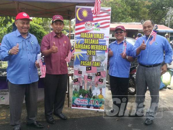 Zamri (dua dari kiri) melakukan gimik perasmian Majlis Pelancaran Program Jualan Jimat Belanja Ambang Merdeka@Pasar Tani Peringkat Kedah 2019 di Pasar Tani Taman Wira Mergong di sini hari ini.