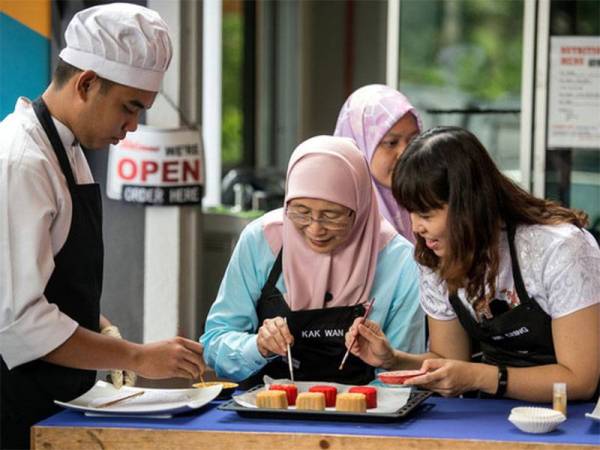 Timbalan Perdana Menteri Datuk Seri Dr Wan Azizah Wan Ismail (tengah) bersama Timbalan Menteri Pendidikan Teo Nie Ching (kanan) dan pelajar keperluan khas sijil asas kulinari dan Wan Fikri Irfan (kiri) melakukan demonstrasi pembuatan kuih bulan ketika Majlis Rakaman Video dan Lawatan Timbalan Perdana Menteri di Kolej Komuniti Selayang hari ini. - Foto BERNAMA