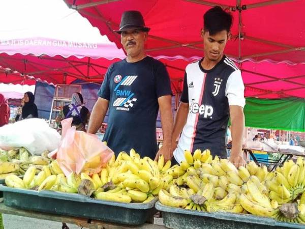 Amran membantu bapanya menjual pisang dan petai di Pasar Lambak, Gua Musang.