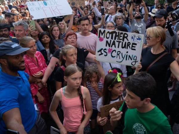 Greta Thunberg (dua dari kiri, baju merah jambu) menyertai protes aktivis alam sekitar di luar ibu pejabat PBB di New York semalam.
