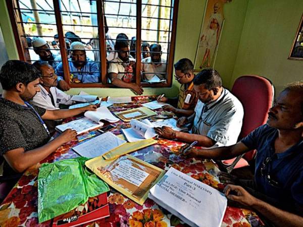 Orang ramai menunggu untuk memeriksa nama dalam senarai draf di Pusat Pendaftaran Kebangsaan di sebuah kampung di daerah Nagaon, Assam, India.