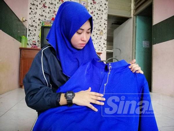 Nur Aishah menunjukkan baju Melayu terakhir yang dipakai Allahyarham.