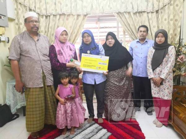 Nora (empat dari kanan) menyampaikan bayaran Faedah Pengurusan Mayat (FPM) sebanyak RM2,000 kepada keluarga Rasyidi di Kampung Senor, Meranti.