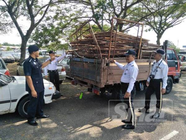 Ahsmon (kiri) melihat lori curi berkenaan yang dirampas susulan penahanan dua lelaki oleh anggota BSPTD IPD Kota Tinggi, Jumaat lalu.