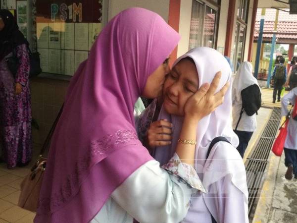 Nor Amidah mencium anaknya Izzatul Aliyah sebelum peperiksaan UPSR bermula di SK Bandar Pontian, hari ini.