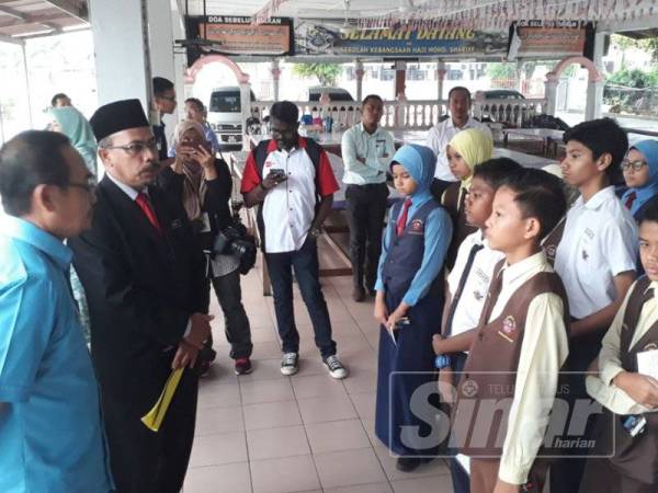 Timbalan Pengarah JPN kedah, Ismail Othman (tiga kiri) memberikan kata-kata semangat kepada murid-murid darjah enam SK Haji Mohd Sharif, Alor Setar sebelum mereka masuk ke dewan peperiksaan pagi ini.