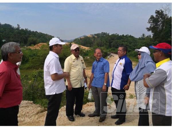 Radzi (kiri, dua) mendengar penerangan daripada JKR ketika melawat tapak pembinaan Lebuh Raya Kota Bharu -Kuala Krai di Kampung Bukit Tiu di sini hari ini.