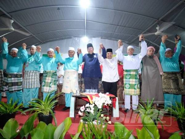 Idris (empat dari kanan) dan Annuar (lima dari kanan) bersama barisan pimpinan UMNO dan Pas pada Himpunan Penyatuan Ummah di Pokok Sena semalam. FOTO: ROSHILLA MURNI ROSLI