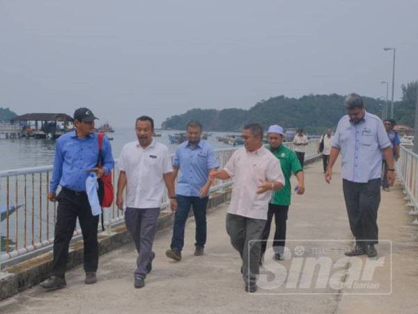 Azman (dua dari kanan) bersama Zawawi dan pegawai agensi terbabit ketika melawat Pulau Redang.