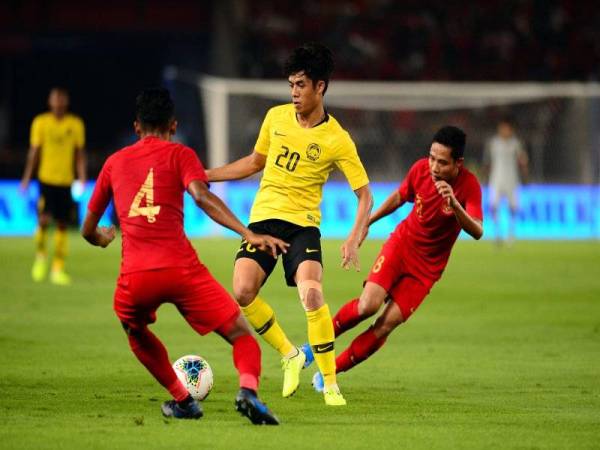 Pemain Kebangsaan, Muhammad Syafiq Ahmad (tengah) diasak pasukan Indonesia pada aksi sulung pusingan kedua Kumpulan G Kelayakan Piala Dunia 2022/Piala Asia 2023 di Stadium Gelora Bung Karno di Jakarta malam tadi. - Foto Bernama