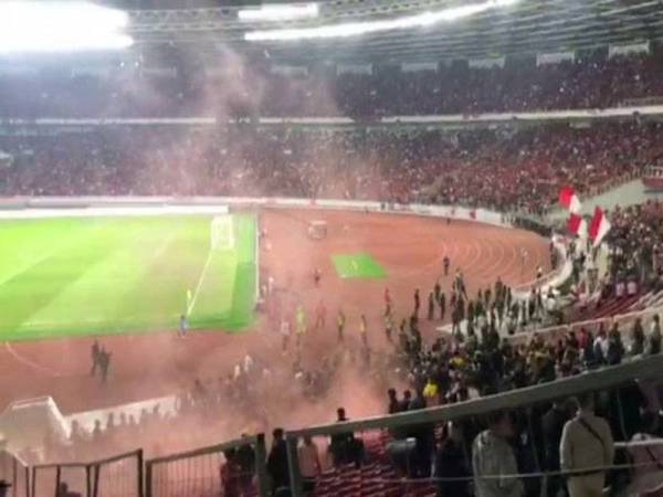 Keadaan cemas ketika penyokong Malaysia dihujani botol dan batu di Stadium Utama Gelora Bung Karno pada Khamis. - Foto Astro Awani