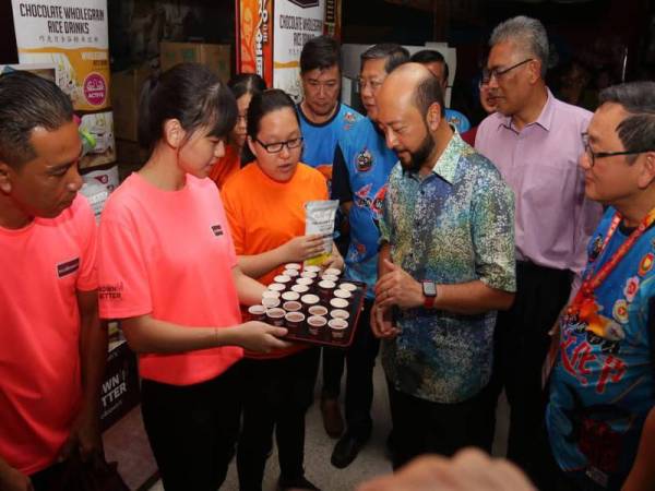 Mukhriz (tiga dari kanan) sempat meluangkan masa untuk melihat pameran jualan makanan yang turut disediakan sempena Pesta Kebudayaan Cina Malaysia ke-36 di Alor Setar malam tadi. - FOTO: MUKHRIZ MAHATHIR FC