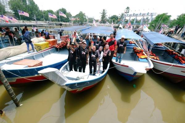 Muhammad Faiz (kiri) menyerahkan sumbangan kepada nelayan, Suhaimi Othman (tengah) pada Program Kibar Jalur Gemilang sempena Sambutan Hari Malaysia bersama nelayan di Kuala Jerlun di sini hari ini.