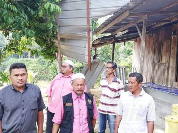 Razali (tengah) melawat kediaman mangsa yang terlibat dengan ribut.