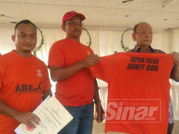 Suhaimi (kanan) menyempurnakan acara simbolik perasmian Karnival Mega Merdeka Majlis Perwakilan Komuniti Kampung (MPKK) di Felda Bukit Goh hari ini.