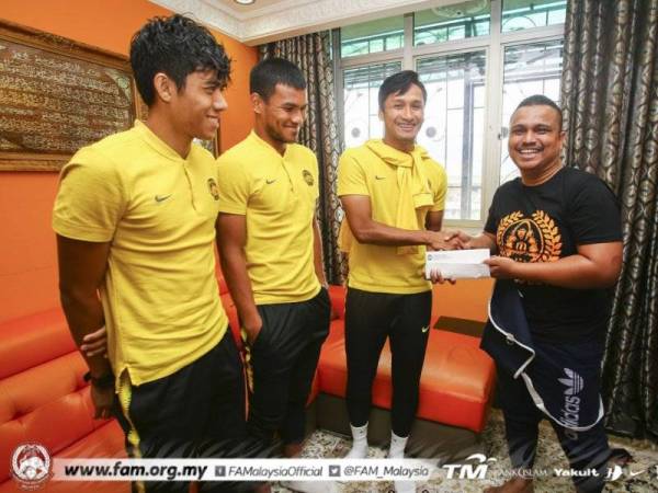 Mohd Zulrani (kanan) menerima sumbangan termasuk tiket menentang UAE daripada kapten Harimau Malaya, Farizal Marlias sambil disaksikan oleh (dari kiri) Syafiq Ahmad dan Shahrul Saad. FOTO: FAM