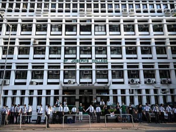 Pelajar sekolah di Hong Kong membentuk rantaian manusia sambil melaungkan slogan protes pro-demokrasi. - Foto AFP