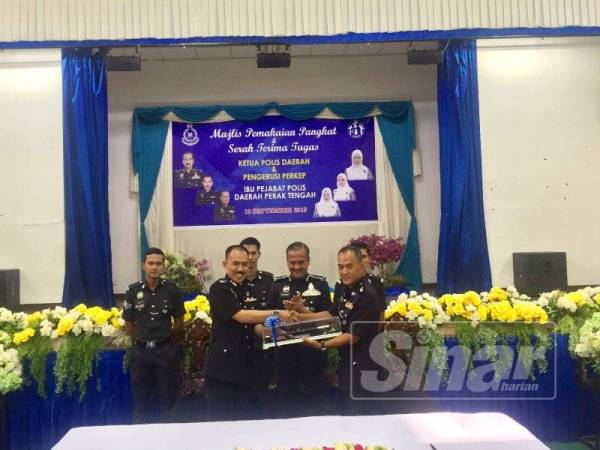 Razarudin (tengah) menyaksikan Mohamad Zainal (kiri) menyerahkan tongkat kuasa kepada Barudin pada Majlis Pemakaian Pangkat dan Serah Tugas Ketua Polis Daerah dan Pengerusi Persatuan Keluarga Polis (Perkep) Ibu Pejabat Polis Daerah (IPD) Perak Tengah hari ini.