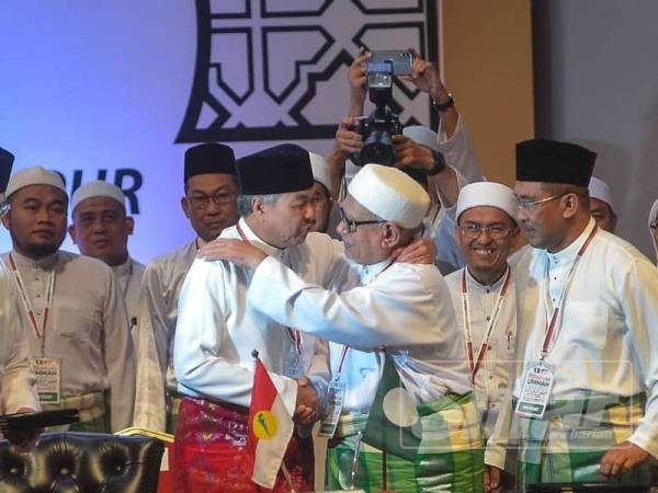 Presiden UMNO, Datuk Seri Ahmad Zahid Hamidi dan Presiden Pas, Datuk Seri Abdul Hadi Awang berpelukan selepas menandatangani Piagam Muafakat Nasional pada Himpunan Penyatuan Ummah di PWTC semalam. - Foto SHARIFUDIN ABDUL RAHIM