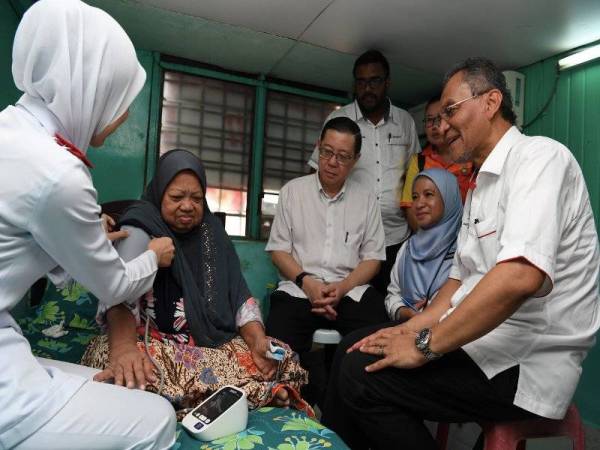 Dr Dzulkefly (kanan) dan Guan Eng (tiga dari kiri) yang juga Ahli Parlimen Bagan memerhatikan seorang jururawat memeriksa kesihatan Ramlah Hamid, 70, di Kampung Sungai Nyior hari ini. - Foto: Bernama