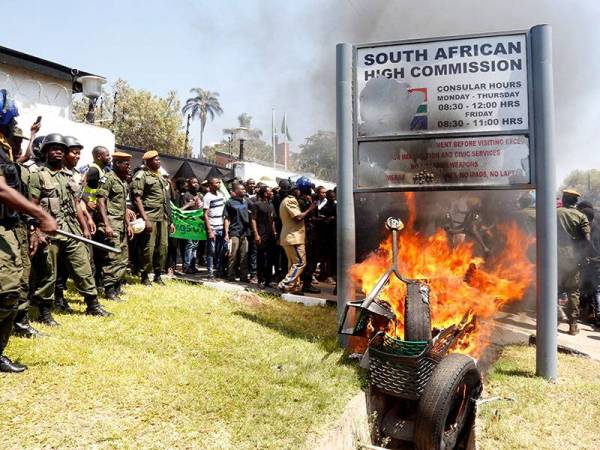 Pelajar universiti Zambia membakar papan tanda di luar Kedutaan Afrika Selatan di Lusaka sebagai membantah serangan xenofobia. - Foto AFP