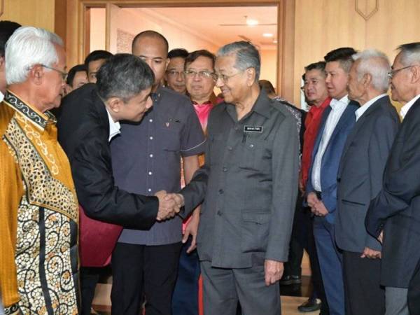 Dr Mahathir bersalaman dengan orang ramai dan pemimpin akar umbi sebaik sahaja tiba di Lapangan Terbang Antarabangsa Kuching untuk menghadiri Sambutan Hari Malaysia di Stadium Perpaduan Negeri Sarawak malam ini. Foto: Bernama