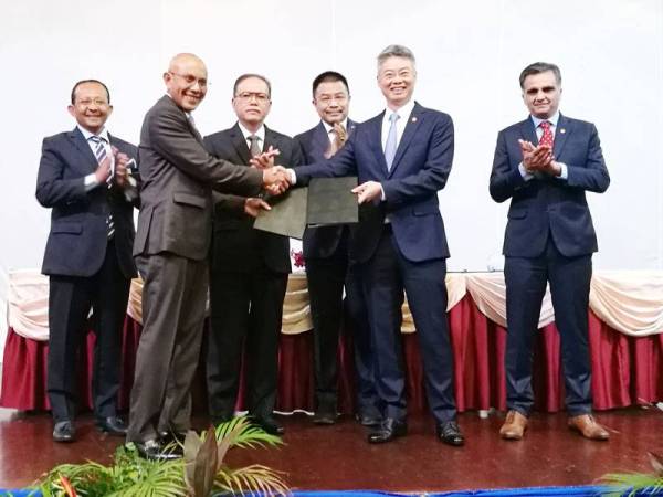 Sallehuddin (dua, kiri) bersalaman dan menyerahkan dokumen MoU dengan Iain sambil disaksikan Wan Rosdy (tiga,kiri) pada Majlis Menandatangani Memorandum Persefahaman (MoU) Berkaitan 'Carbon Trading' Antara Kerajaan Pahang dan Shell Malaysia di Hotel Grand Makmur, di sini, hari ini.