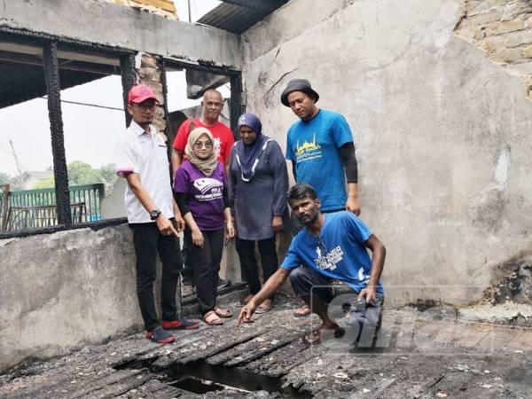 Mohd Azmil (kiri) bersama pegawainya menziarahi Tilagavati (tiga dari kanan) selepas rumah terbabit terbakar kelmarin.