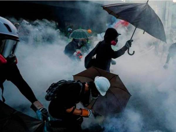 Polis Hong Kong turut melepaskan meriam air kimia dan gas pemedih mata kepada penunjuk perasaan yang melemparkan bom molotov di luar pejabat kerajaan Hong Kong. - Foto Reuters