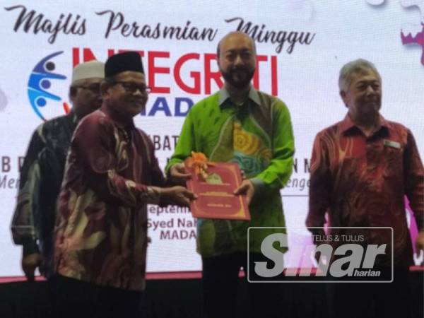 Mukhriz (tengah) menyerahkan sijil kepada wakil PPK sempena perasmian Minggu Integriti MADA dan Sesi Libat Urus Bersama Pemimpin Peladang MADA di Ibu Pejabat MADA di Ampang Jajar di sini hari ini.