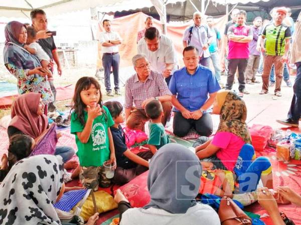 Ismail Sabri (dua dari kanan) bertanya keadaan penduduk yang tinggal dalam khemah sejak rumah mereka dirobohkan semalam.