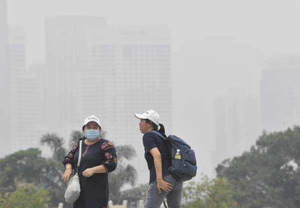 Pengunjung tempat awam memakai topeng muka berikutan keadaan yang berjerebu ketika tinjauan di Taman Tasik Perdana hari ini. -Foto Bernama