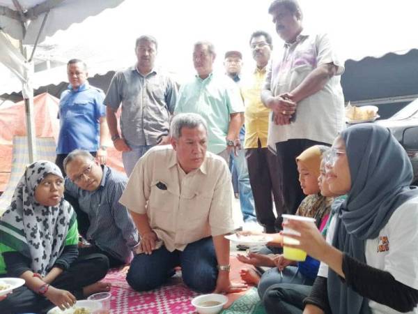 Mat Nadzari bertemu penduduk yang tinggal dalam khemah selepas rumah mereka dirobohkan bagi laluan projek pelebaran sungai di Paya Jaras Hilir, Sungai Buloh.