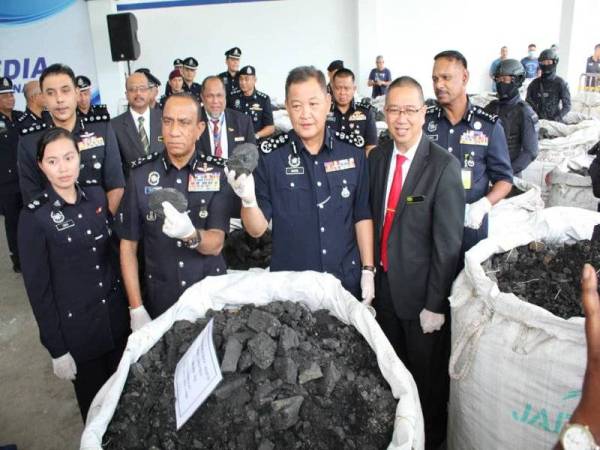 Abdul Hamid (tengah) menunjukkan kokain yang dicampur dengan arang batu bernilai RM2.4 bilion yang dirampas.