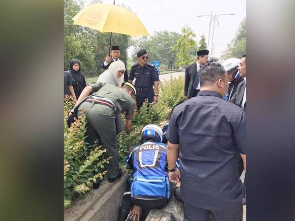 Raja Permaisuri Agong mencemar duli membantu anggota polis yang terlibat dalam kemalangan semasa mengiringi kenderaan baginda di lampu Isyarat Jalan Semarak di sini petang tadi. FOTO: IHSAN PEMBACA