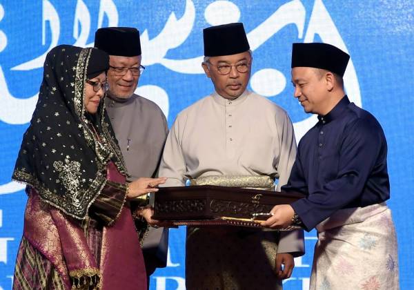 Yang di-Pertuan Agong Al-Sultan Abdullah Ri'ayatuddin Al-Mustafa Billah Shah berkenan menyampaikan Anugerah Sastera Negara ke-14 kepada Prof Dr Siti Zainon Ismail pada Majlis Pengurniaan Anugerah Sastera Negara ke-14 malam ini. Turut hadir Menteri Pendidikan, Dr Maszlee Malik (kanan). Foto: BERNAMA
