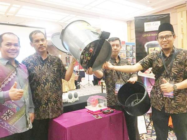 Ahmad (dua dari kiri) bersama kumpulannya menunjukkan alat perangkap tikus yang diinovasikan oleh mereka. - FOTO NORAWAZNI YUSOF