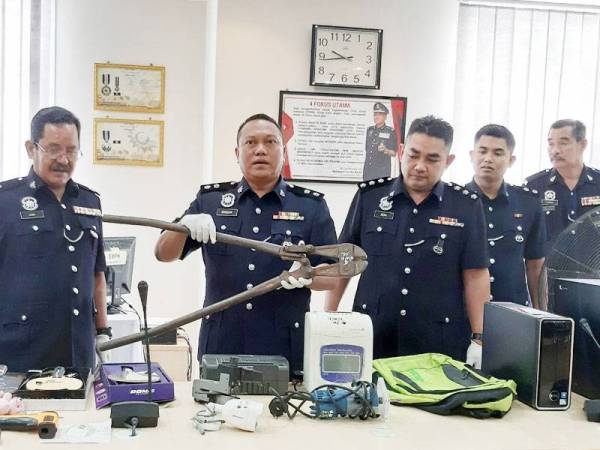 Mohd Khaizam (tengah) menunjukkan pemotong besi yang dirampas daripada dua kumpulan yang aktif dalam kes pecah rumah dan kilang sekitar Sungai Siput hari ini.