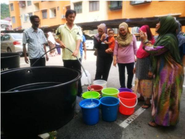 Penduduk Blok E Rumah Pangsa Pantai Peringgit sedang menunggu giliran untuk mengisi air.