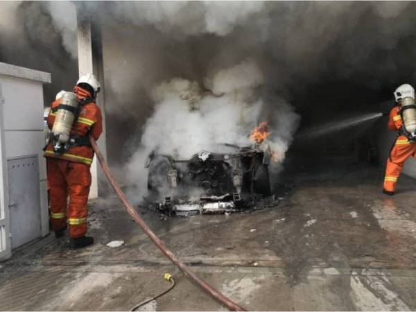 Anggota Bomba dan Penyelamat sedang memadamkan kebakaran sebuah kereta di Seksyen U12 di sini.