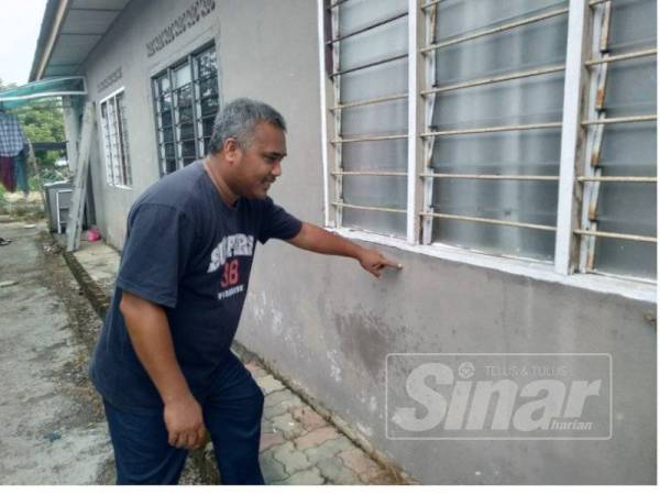 Abdul menunjukkan paras air yang naik sewaktu banjir pada lima tahun lalu.