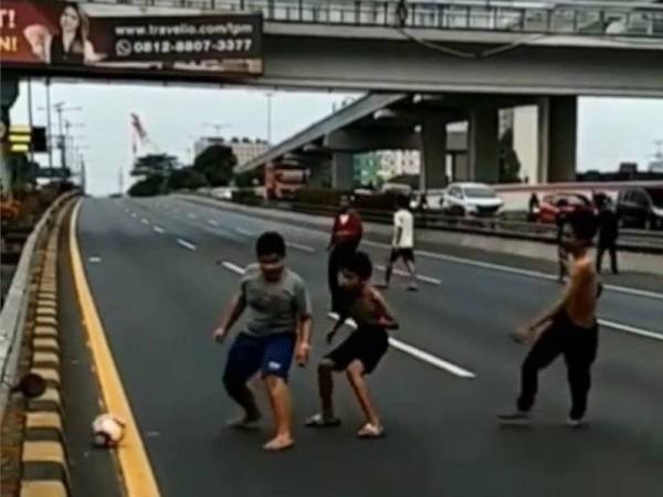 Beberapa remaja mengambil peluang bermain bola selepas akses ke laluan tol ditutup susulan demonstrasi.