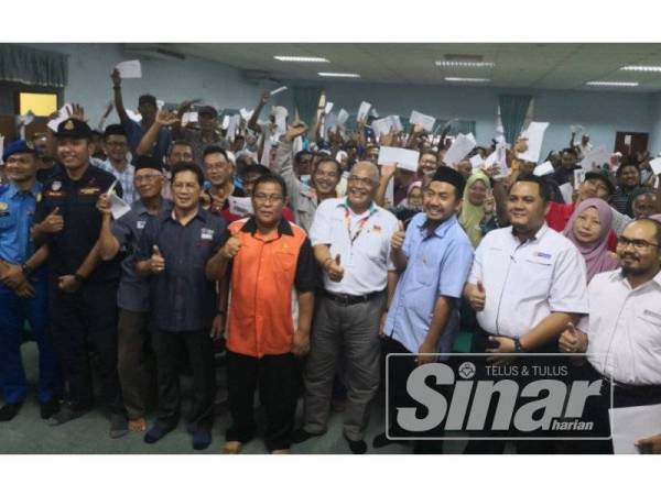 Ahmad Mustain (lima dari kanan) bergambar bersama tetamu yang hadir dan penduduk pada majlis penyerahan bantuan bencana ribut DUN Sabak di Balai Rakyat Taman Berjaya di sini semalam.