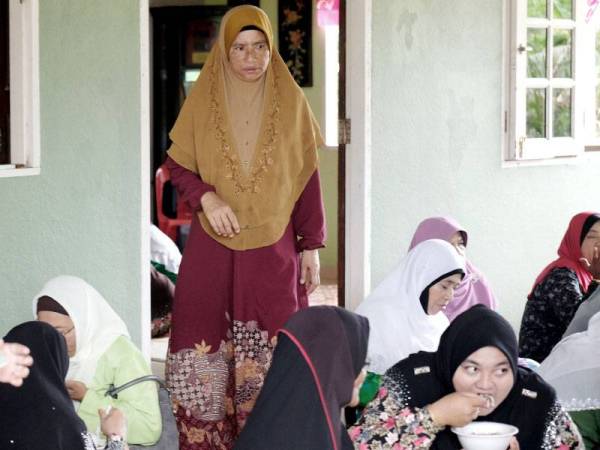 Ibu kepada Allahyarham Muhammad Adib Mohd Kassim; Asma Aziz, 52, (berdiri, tengah) melayani tetamu yang hadir pada Majlis Tahlil dan Bacaan Surah Yasin untuk Allahyarham di kediaman mereka di Kampung Tebengau hari ini. --fotoBERNAMA