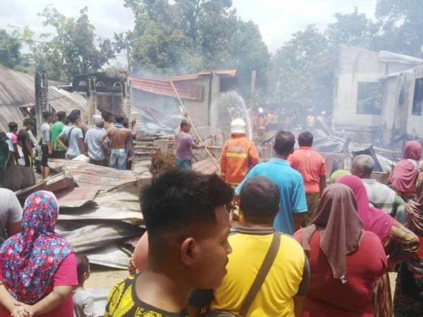 Orang ramai melihat keadaan rumah yang musnah.